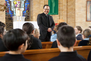 Parish priest of St Michael's Catholic Parish speaking to school children inside church